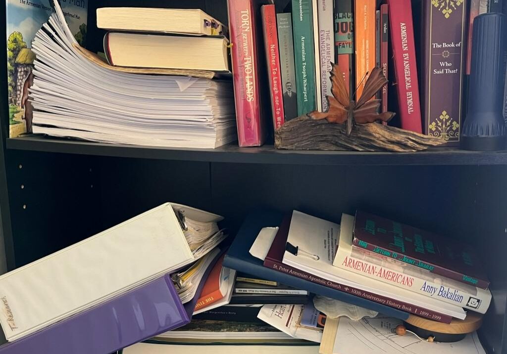 A bookshelf with books and papers on it.